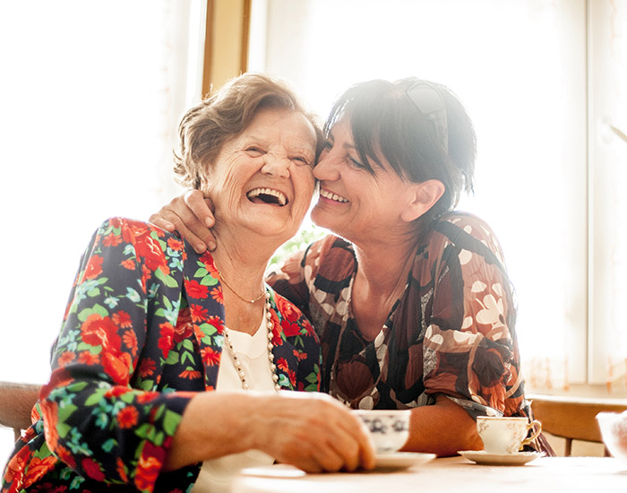 Two ladies laughing at table