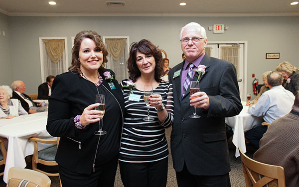 Three people toasting to the new Kroft Commons while at the ribbon-cutting ceremony.